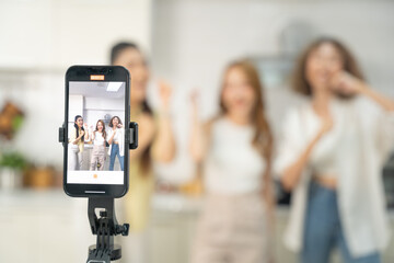 Smartphone on a tripod recording a lively moment of three friends laughing and enjoying themselves...