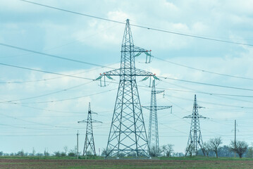 High voltage towers with sky background. Power line support with wires for electricity transmission. High voltage grid tower with wire cable at distribution station. Energy industry, energy saving