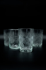 pile of glasses with water on black background