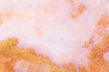 White and pink acrylic paints with shimmering golden glitter. Colorful liquid paint abstract...