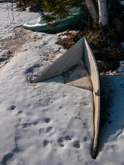 boat buried underneath the snow and ice on shore