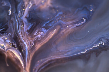 Blue and purple acrylic paints with golden glitter. Liquid paint abstract background.