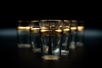 glass of water with gold rings on black  close up