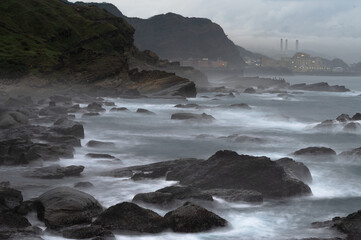 Long exposure of coastline with tide and rocks, like clouds flowing between it, in Keelung city, Taiwan.