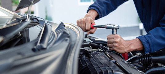 Professional mechanic working on the engine , repairing a car engine automotive workshop with a...