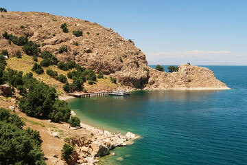 View onto the little pier, jetty on Akdamar Island on Lake Van, Van Gölü surrounded by a bay with intense blue, green, turquoise water, Van, Turkey