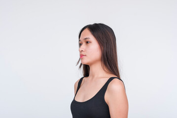 45 degree view of a young asian woman in a black bodysuit. Isolated on a white background.