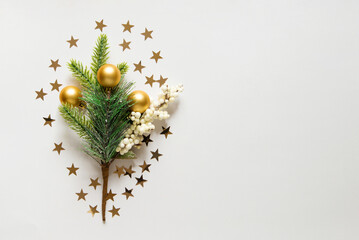 new year background with christmas tree, golden toys and star confetti on a light white background....