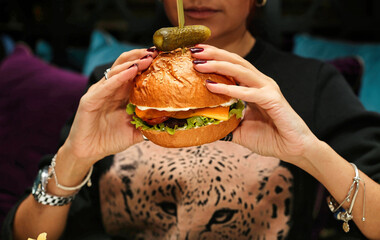 Woman Holding a Large Hamburger in Front of Her Face