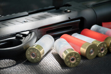 Shotgun, shotgun cartridges on a black leather background, soft and selective focus