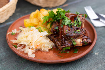 Bavarian baked pork ribs with boiled potatoes and sauerkraut closeup - 798748443