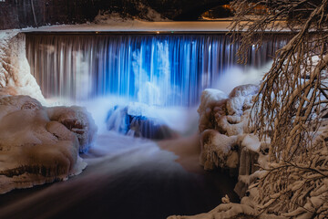 Small waterfall in winter lit up in blue and white for Finnish independence day, Helsinki Finland