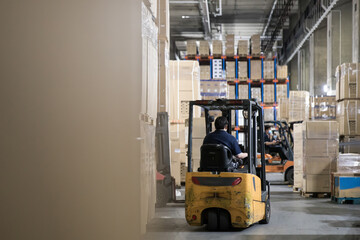 Forklift operator in bustling industrial storage facility