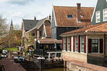 Typical wooden houses with gables along the river in the Dutch picturesque village of De Rijp in the Beemster.
