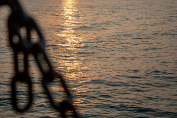 Anchor chain and sea. Chain close-up on the background of the sea at sunset. Sea waves in the...