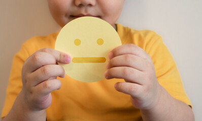 feedback concept, paper cut stressed face in hand fat kid put yellow tight shirt chest. positive thinking, assessment and world mental health day.