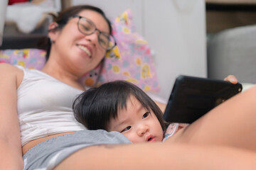 Close up happy mother and daughter kid using the smart phone