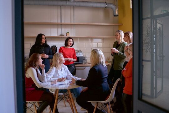 female office staff having a coffee break in the office kitchen