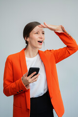 Naklejka premium Portrait of woman standing holding smartphone mugand looking outside, isolated on background.