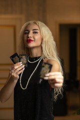 Portrait of a young beautiful blonde girl in a black dress in the studio.