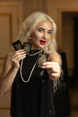 Portrait of a young beautiful blonde girl in a black dress in the studio.
