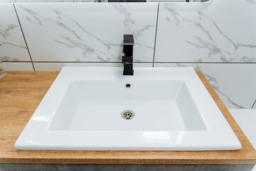 Wooden countertop with rectangleshaped black faucet fixture