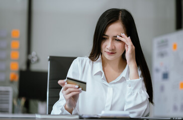 Business woman stressed with credit card debt to shopping online in internet website shop with...