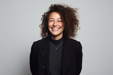 Fototapeta premium Portrait of a beautiful young woman with curly hair laughing and looking at camera