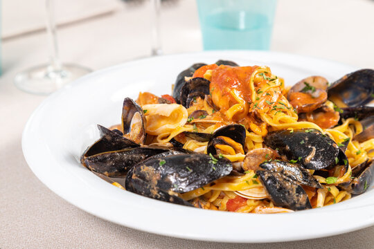 Tagliolini allo scoglio, homemade Italian pasta with mussels, clams, calamari, scampi, prawns and tomato. Seafood tagliolini
