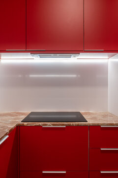 Minimalist red kitchen cabinet design with sleek handles and marble countertop