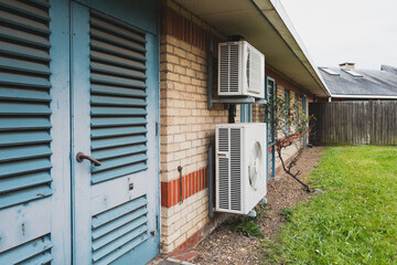 Dual Air Conditioning units seen attached to the outside wall of an NHS hospital in England. Nearby...