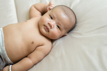 Adorable asian baby boy relaxing on bed,Newborn child