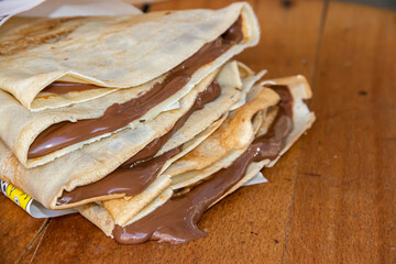 Pile of home made pancakes filled with dripping melted hot chocolate, chocolate drips down the table out of the pancakes