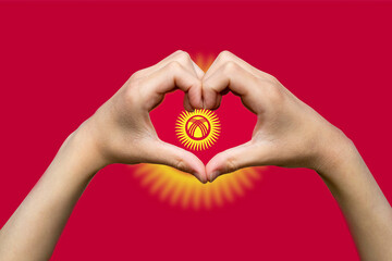Kyrgyzstan flag with two hands heart shape, express love or affection concept, support or donate 