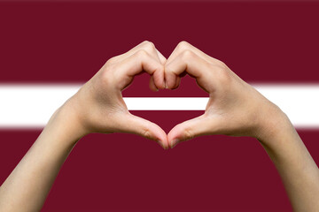 Latvia flag with two hands heart shape, hand heart love sign, patriotism and nationalism idea