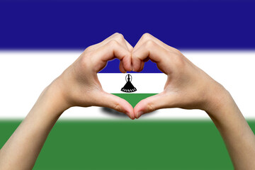Lesotho flag with two hands heart shape, patriotism and nationalism idea, vector design, express 