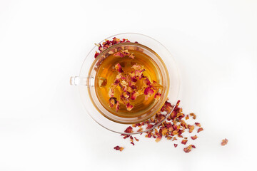 Tea made from tea rose petals in a glass bowl on white background