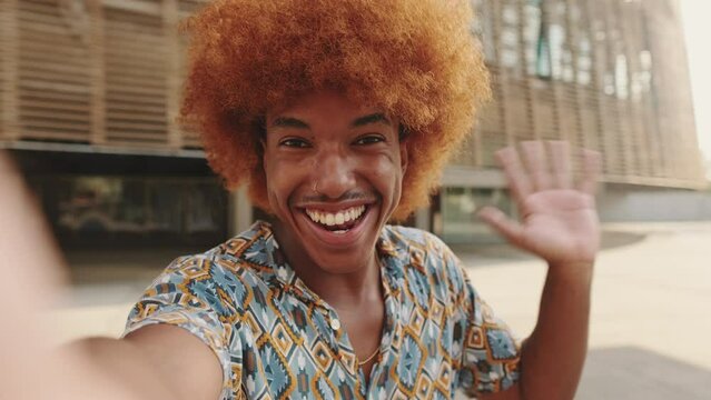 Close-up of young influencer holding camera and broadcasting vlog
