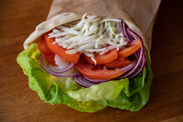 A delightful vegetarian healthy sandwich bursting with flavors. Crisp green salad leaves, juicy tomatoes, savory white cheese, and zesty onions, all nestled between slices of fresh bread