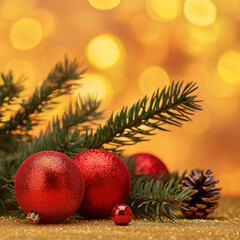 Christmas balls with fir twigs in front of blurred yellow background