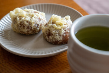 テーブルに載せた日本の郷土料理、天ぷらまんじゅうとお茶