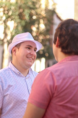 Obraz premium Couple of gay men looking at each other on the street casual dresses, vertical image. LGBT love concept