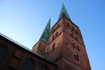Historic old church in Lübeck in a worm's eye view with a bright blue sky
