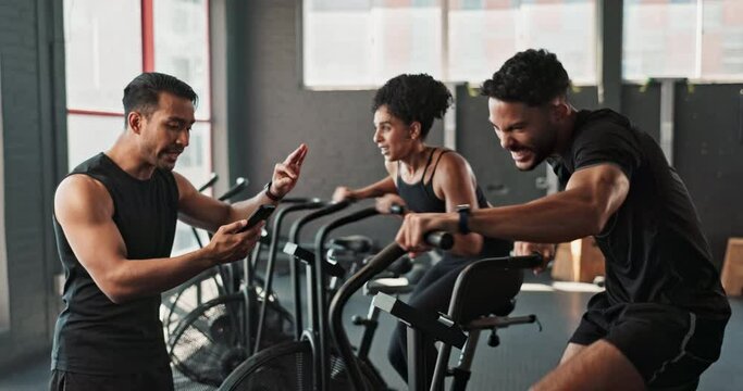 Cycling, instructor and bicycle in gym for exercise, high five in training class for body wellness or workout goal. Coach, cardiovascular fitness or joint mobility, client progress and equipment
