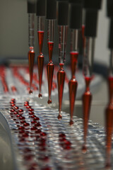 Red glass tubes moving along a conveyor belt in a factory setting