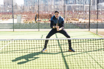 A padel player jump to the ball, good looking for posts and poster. Man with black racket playing a...