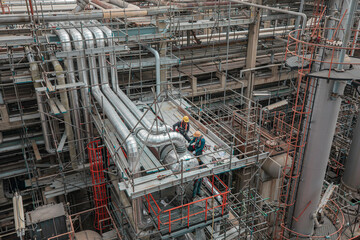 Male worker inspection at steel long pipes and pipe elbow in station oil factory fin fan during refinery valve of visual check record pipeline heat exchanger