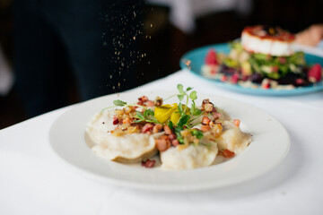 dumplings with meat and microgreens sprinkled with pepper