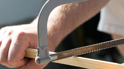 Hand saw with hardened teeth isolated. saw in hand, hacksaw at work. cut the wood plank. close-up. repair concept, construction material cutting, working tool.