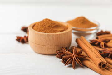 Cinnamon sticks and anise on a textured background. Cinnamon roll and star anise. Spicy spice for baking, desserts and drinks. Fragrant ground cinnamon.Place for text. copy space.